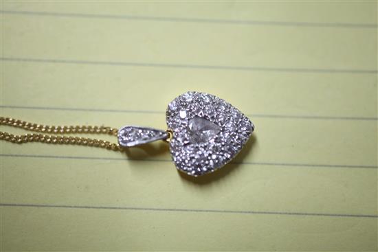 An 18ct gold and diamond encrusted heart shaped pendant with central pear shaped diamond, pendant 14mm.